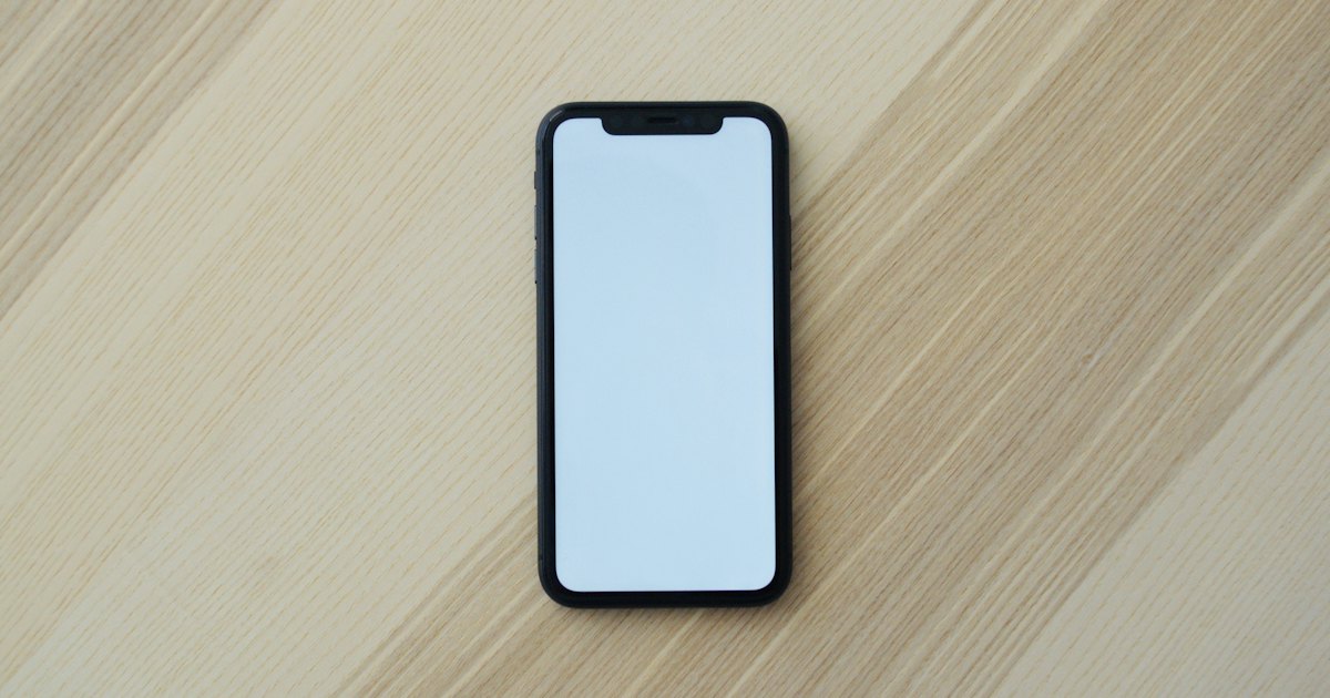 Smartphone appoggiato su un tavolo di legno, schermo vuoto senza chiamate in arrivo